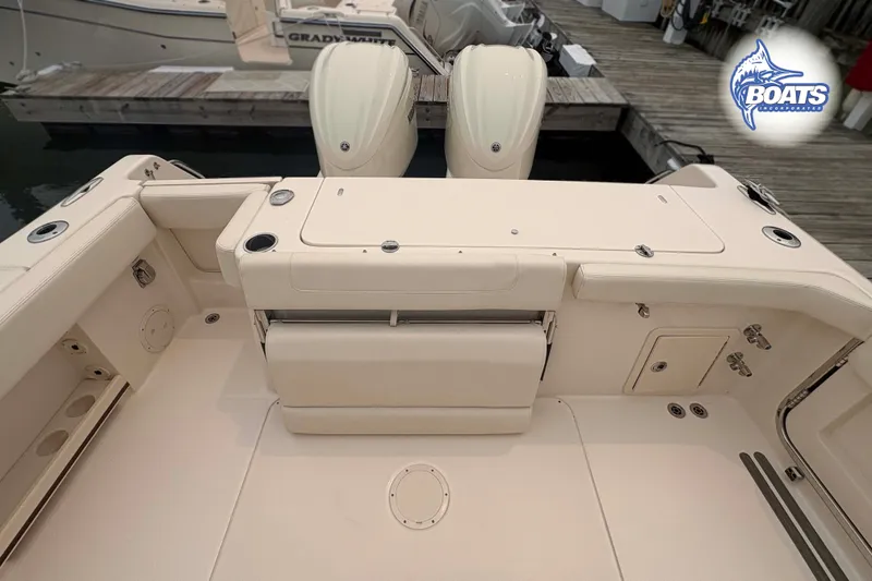 Slide: The Image of 2024 Grady-White Canyon 306 boat deck with twin engines, docked at marina. - 11