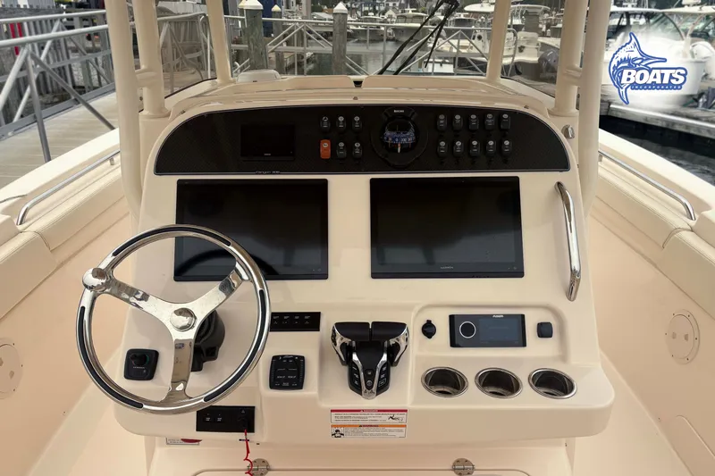 Slide: The Image of 2024 Grady-White Canyon 306 helm with dual displays and modern controls at marina. - 7