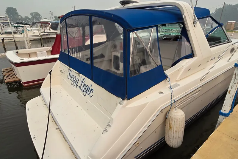 Slide: The Image of 1994 Sea Ray 370 Express Cruiser docked, featuring blue canopy and "Fuzzy Logic" name. - 4