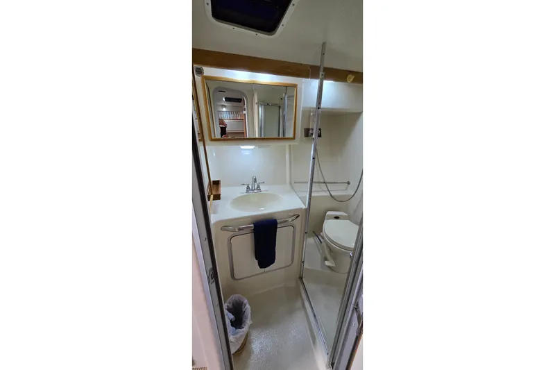 Slide: The Image of Bathroom interior of 1994 Sea Ray 370 Express Cruiser with sink, mirror, and toilet. - 28