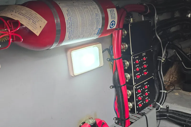 Slide: The Image of Engine room of 1994 Sea Ray 370 Express Cruiser with fire extinguisher and control panels. - 35