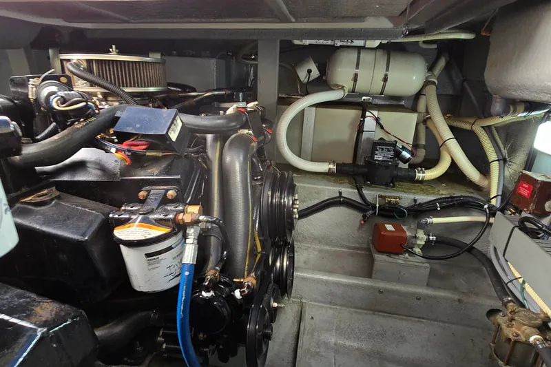 Slide: The Image of Engine compartment of a 1994 Sea Ray 370 Express Cruiser, showcasing mechanical components and wiring. - 38
