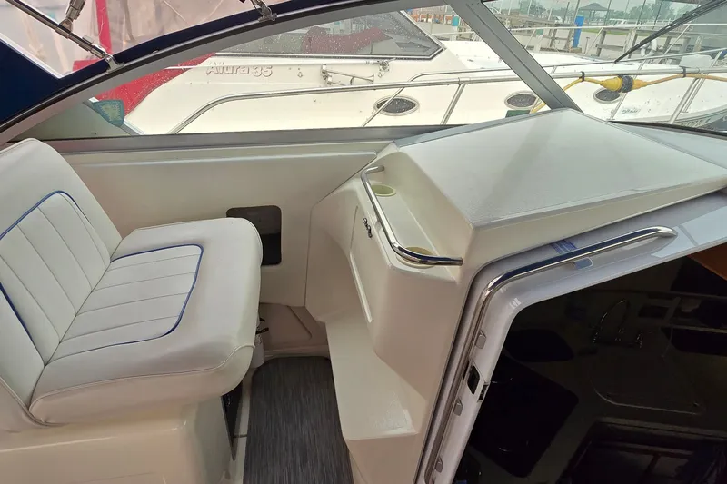 Slide: The Image of 1994 Sea Ray 370 Express Cruiser interior with white seating and helm station. - 15