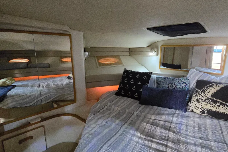 Slide: The Image of Cozy cabin interior of 1994 Sea Ray 370 Express Cruiser with decorative pillows and mirrors. - 27