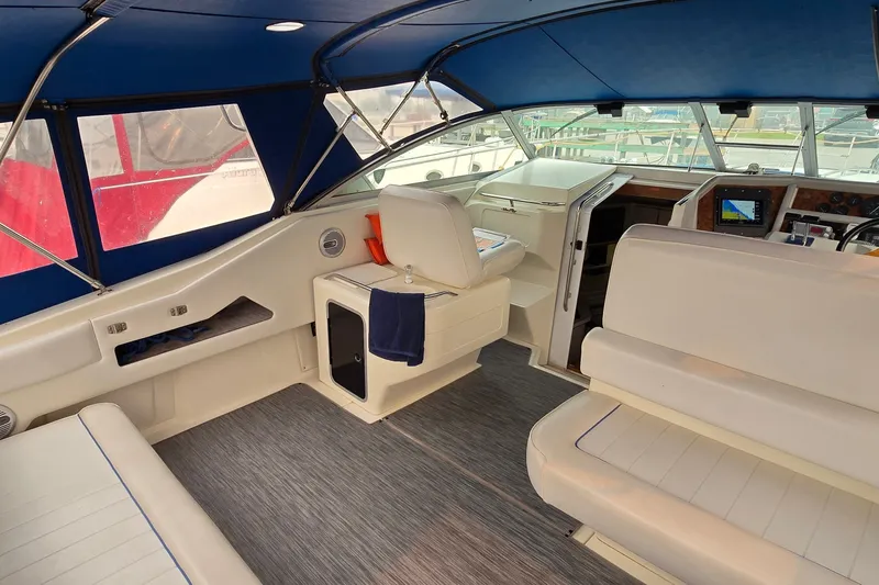 Slide: The Image of 1994 Sea Ray 370 Express Cruiser interior with white seating and blue canopy. - 9
