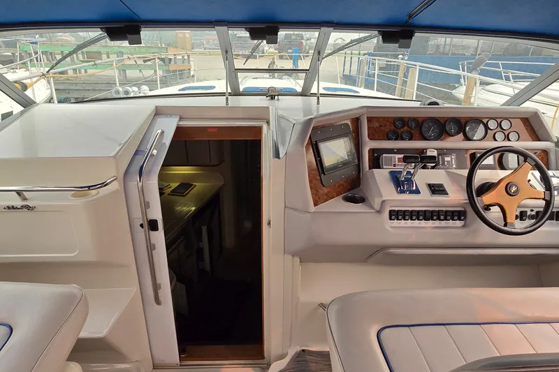 Slide: The Image of 1994 Sea Ray 370 Express Cruiser helm with steering wheel, controls, and navigation instruments. - 18