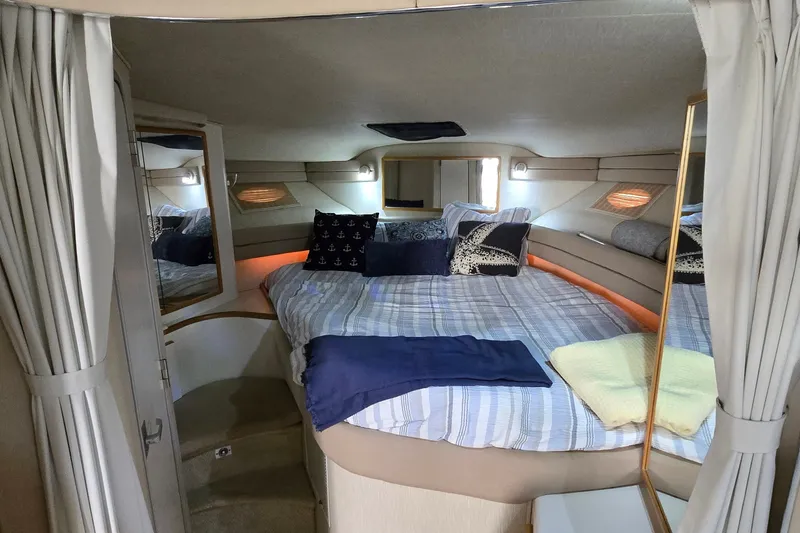 Slide: The Image of 1994 Sea Ray 370 Express Cruiser cabin with cozy bed and nautical decor. - 25
