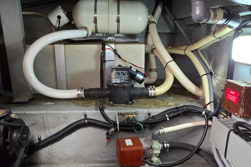 Slide: The Image of Engine room of 1994 Sea Ray 370 Express Cruiser with visible plumbing and equipment. - 40