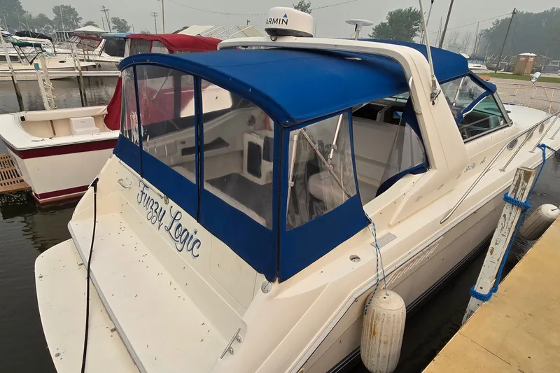 Slide: The Image of 1994 Sea Ray 370 Express Cruiser docked with blue canopy and "Fuzzy Logic" name. - 6