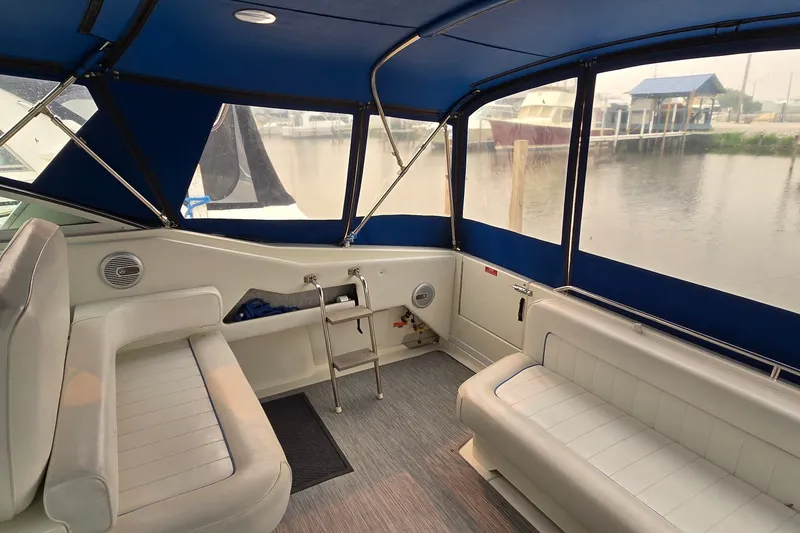 Slide: The Image of Interior of a 1994 Sea Ray 370 Express Cruiser with blue canopy and white seating. - 8