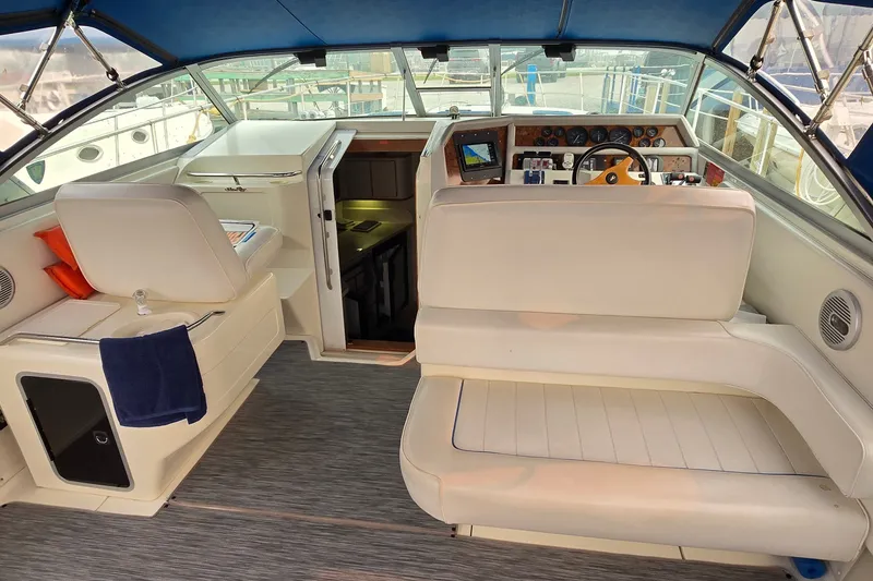Slide: The Image of 1994 Sea Ray 370 Express Cruiser cockpit with white seating and navigation controls. - 10