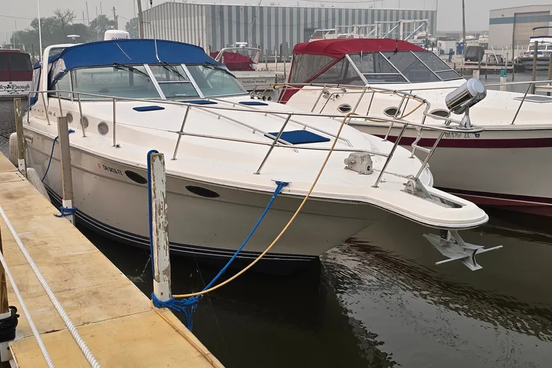 Slide: The Image of 1994 Sea Ray 370 Express Cruiser docked at marina, featuring blue canopy and sleek design. - 2