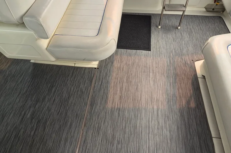Slide: The Image of Interior of 1994 Sea Ray 370 Express Cruiser with gray flooring and white seating. - 19