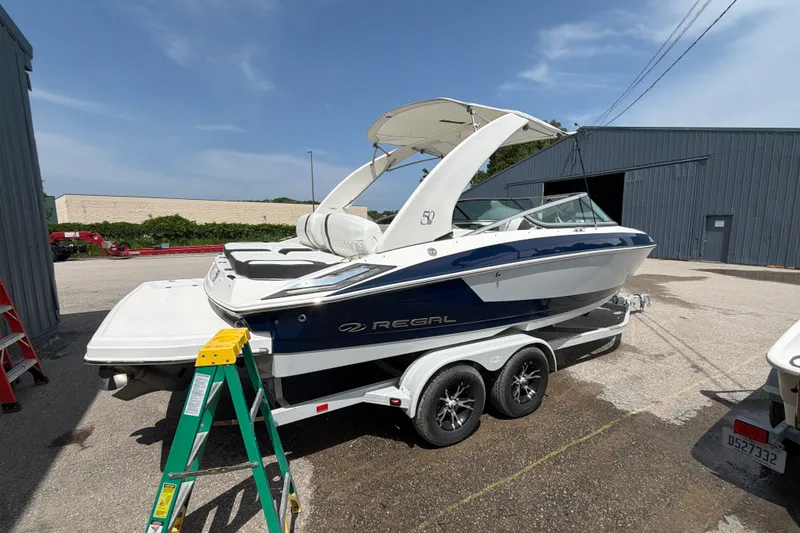 Slide: The Image of A 2020 Regal 2300 Bowrider on a trailer, featuring blue and white paint and a sunshade. - 1