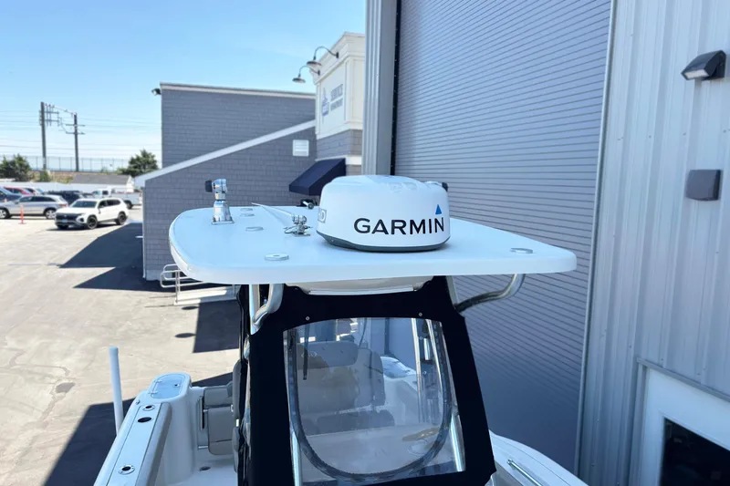 Slide: The Image of 2021 Key West 244 Center Console boat with Garmin radar, docked near a building. - 4