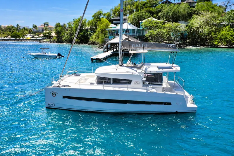 The Image of Sailing catamaran Bali 4.1, 2020 model, anchored in clear blue waters near lush shoreline. - 0