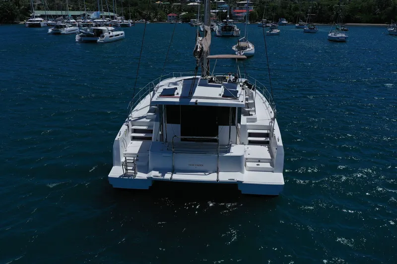 Slide: The Image of 2020 Bali 4.1 catamaran anchored in a serene marina with other boats. - 6