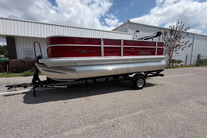 Slide: The Image of 2026 Sun Tracker Bass Buggy 18 DLX pontoon boat on trailer, parked outdoors. - 84