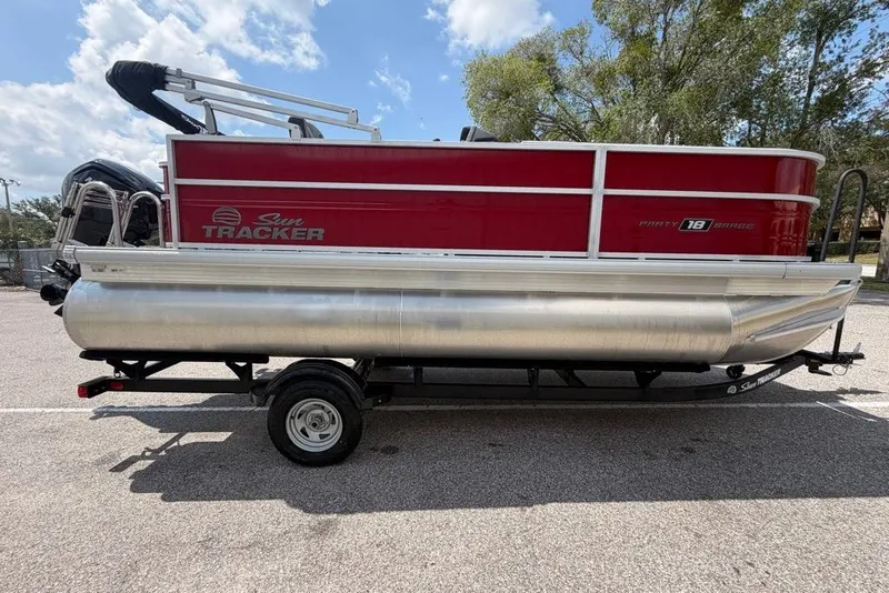 The Image of 2026 Sun Tracker Bass Buggy 18 DLX pontoon boat on trailer, parked outdoors. - 0