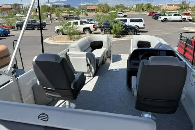 Slide: The Image of 2026 Sun Tracker Party Barge 22 RF DLX pontoon boat interior with seating in a parking lot. - 4