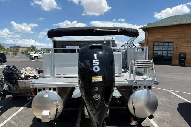 Slide: The Image of 2026 Sun Tracker Party Barge 22 RF DLX pontoon boat with 150 HP engine, parked outdoors. - 1