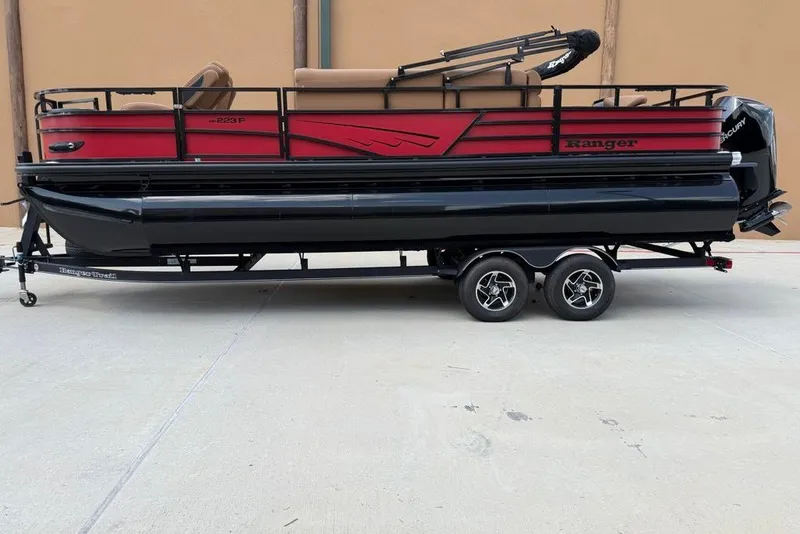 The Image of 2026 Ranger 223F pontoon boat on trailer, featuring red and black design. - 0