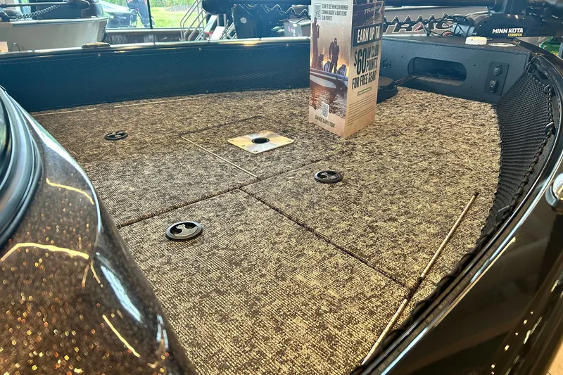 Slide: The Image of 2026 Ranger VS1782SC Angler boat deck with carpeted surface and promotional display. - 8
