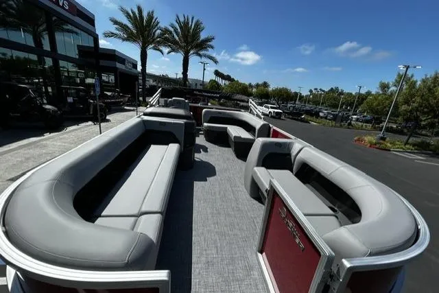 Slide: The Image of 2026 Sun Tracker Party Barge 18 DLX pontoon boat with spacious seating, parked outdoors. - 7