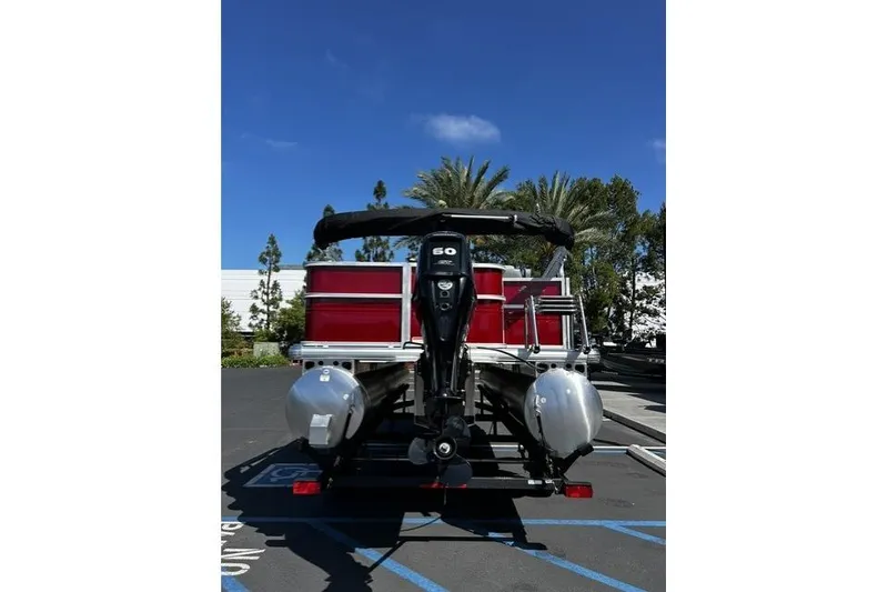 Slide: The Image of 2026 Sun Tracker Party Barge 18 DLX pontoon boat with outboard motor in parking lot. - 10