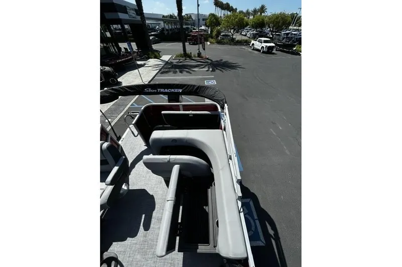 Slide: The Image of 2026 Sun Tracker Party Barge 18 DLX pontoon boat with seating, parked outdoors. - 5