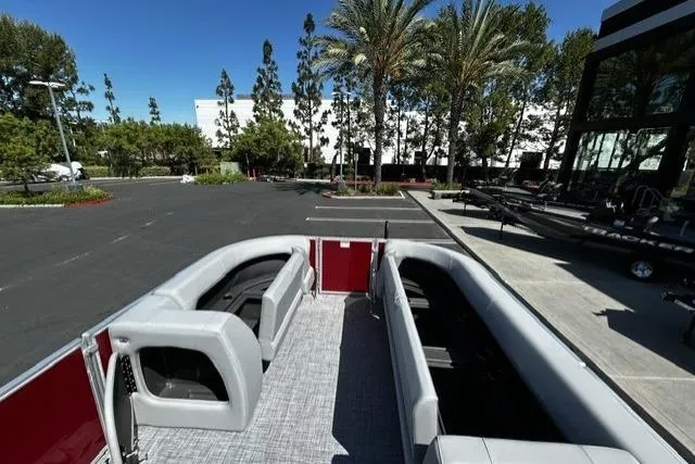 Slide: The Image of 2026 Sun Tracker Party Barge 18 DLX pontoon boat with spacious seating in a parking lot. - 4