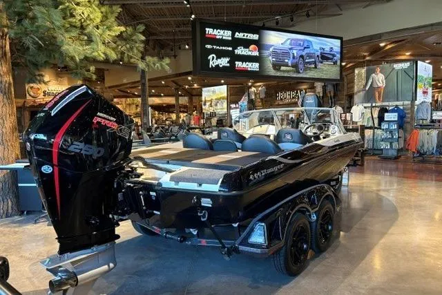 The Image of 2026 Ranger 212LS boat displayed indoors with powerful engine and sleek design. - 0