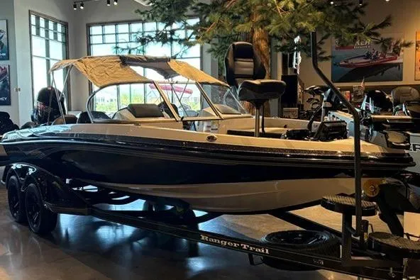 Slide: The Image of 2026 Ranger 212LS boat on trailer in showroom, featuring sleek design and canopy. - 4
