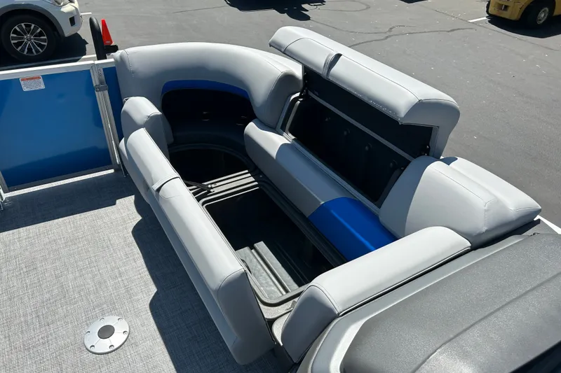 Slide: The Image of 2026 Sun Tracker Party Barge 22 RF XP3 with open storage compartment and gray seating. - 14