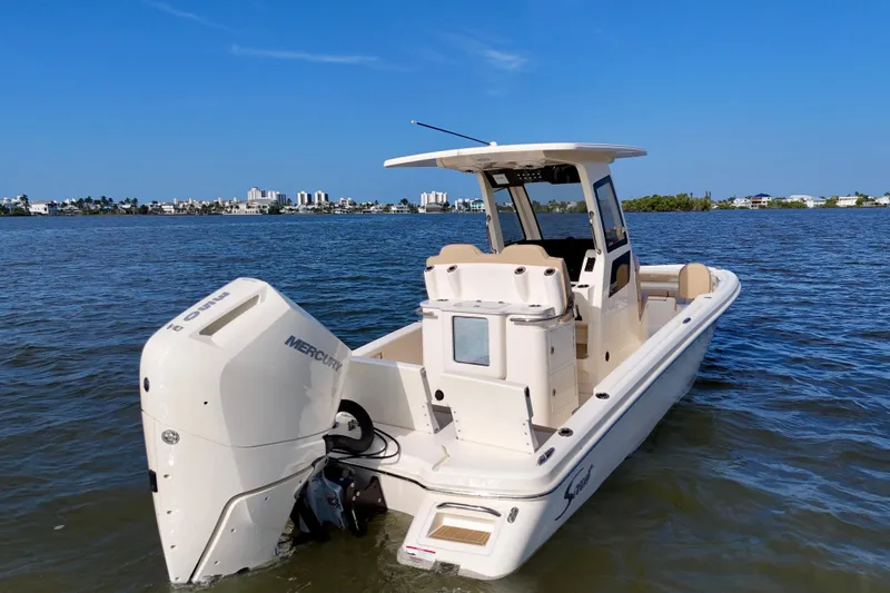 Slide: The Image of 2026 Scout 261 XSS boat with Mercury engine on calm water, cityscape in background. - 15