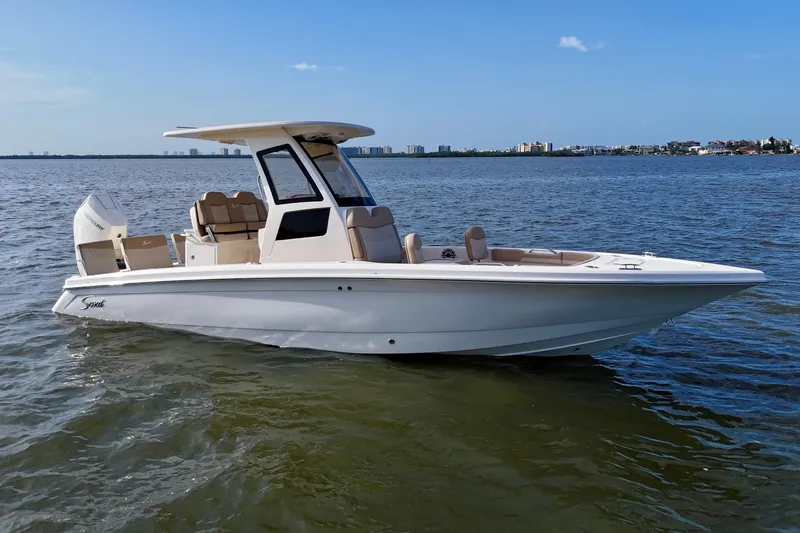 Slide: The Image of 2026 Scout 261 XSS boat on calm water, clear sky background. - 14