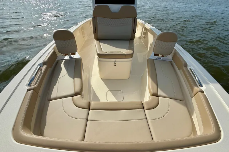 Slide: The Image of Luxurious seating area on 2026 Scout 261 XSS boat, with beige upholstery and water backdrop. - 33