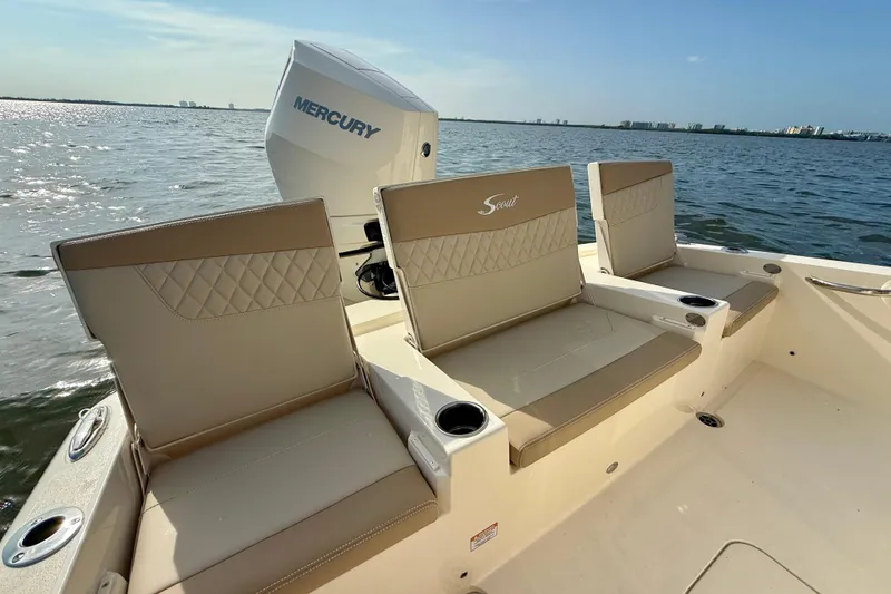 Slide: The Image of 2026 Scout 261 XSS boat with Mercury engine, featuring beige seating and cup holders on a sunny day. - 24