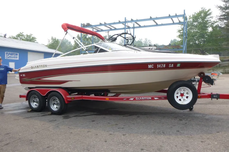 The Image of 2000 Glastron GX 205 Ski & Fish boat on trailer, parked outdoors. - 1