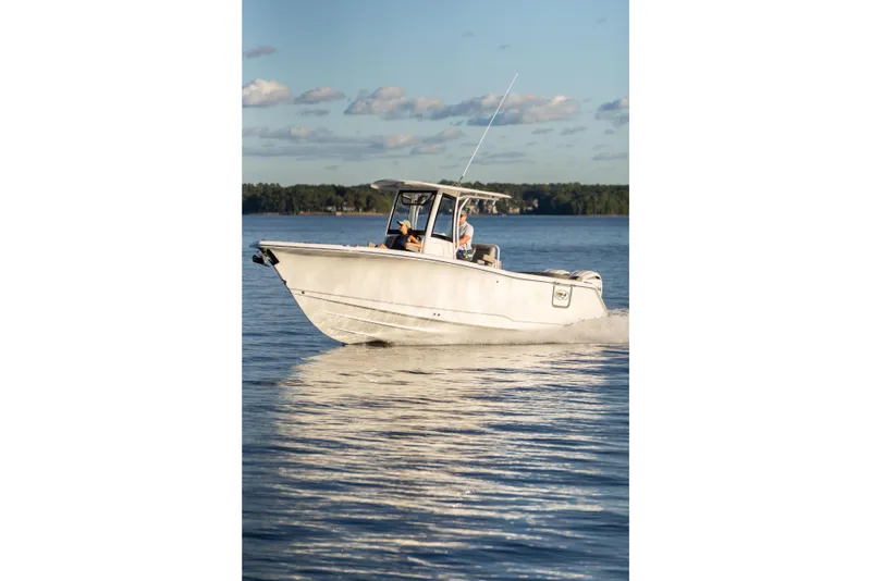 Slide: The Image of 2026 Sea Hunt Ultra 275 Coffin Box boat cruising on a serene lake. - 58