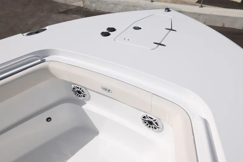 Slide: The Image of 2026 Sea Hunt Ultra 275 Coffin Box boat interior with sleek white design and speakers. - 24