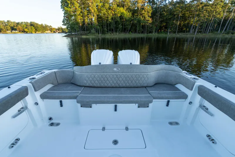 Slide: The Image of 2026 Sea Hunt Ultra 275 Coffin Box boat interior with cushioned seating by a serene lake. - 44