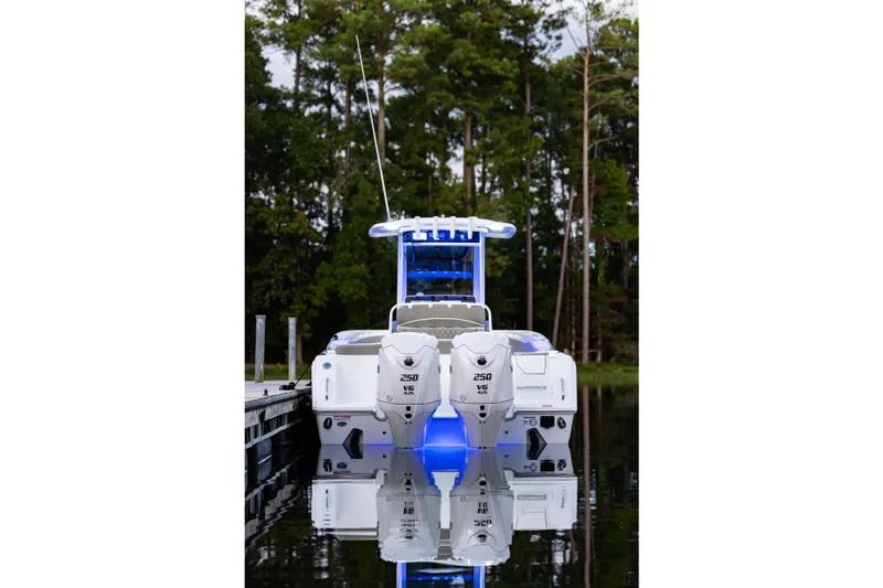 Slide: The Image of 2026 Sea Hunt Ultra 275 Coffin Box boat with dual engines, docked on calm water. - 48
