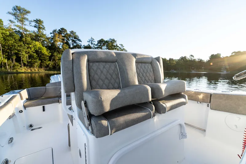 Slide: The Image of 2026 Sea Hunt Ultra 275 Coffin Box boat interior with cushioned seating on a sunny day. - 38