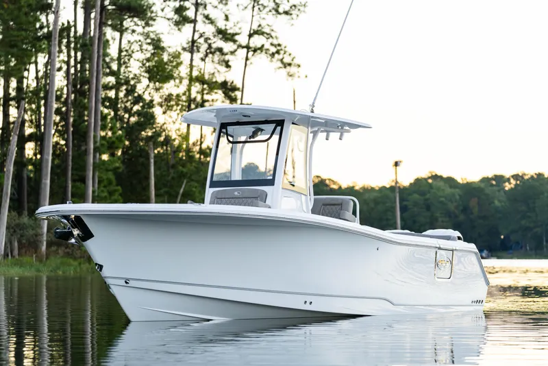 Slide: The Image of 2026 Sea Hunt Ultra 275 Coffin Box boat on calm water, surrounded by trees. - 49
