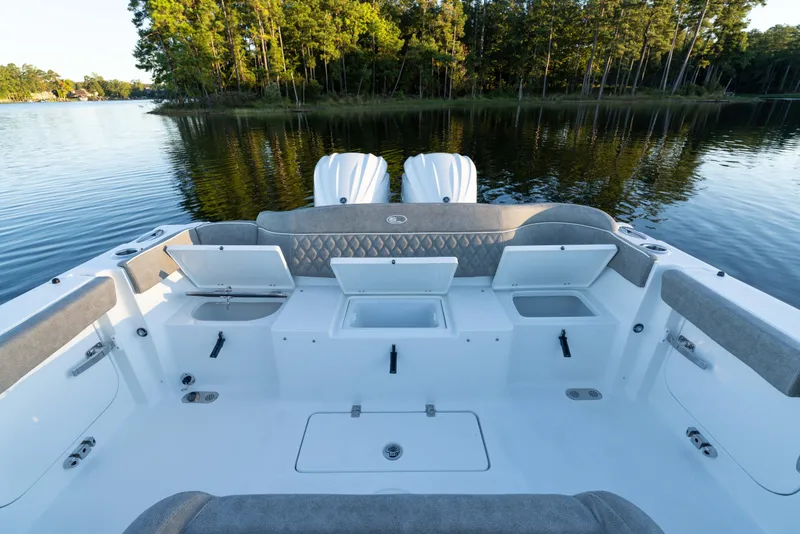 Slide: The Image of 2026 Sea Hunt Ultra 275 Coffin Box boat interior with open storage compartments on a serene lake. - 42