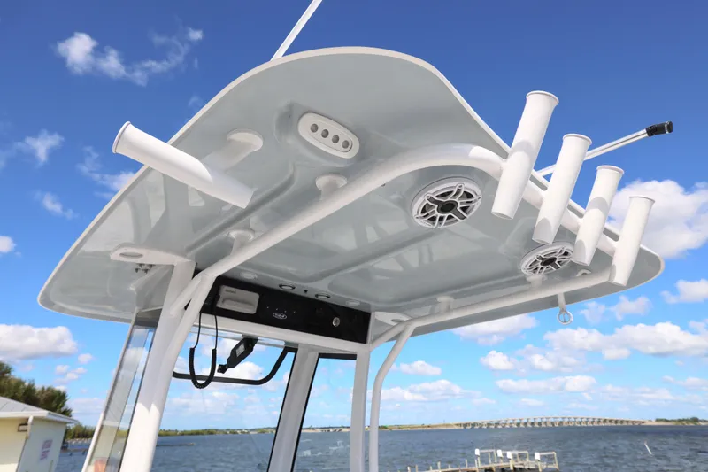 Slide: The Image of 2026 Sea Hunt Ultra 275 Coffin Box boat with rod holders and speakers, under blue sky. - 22