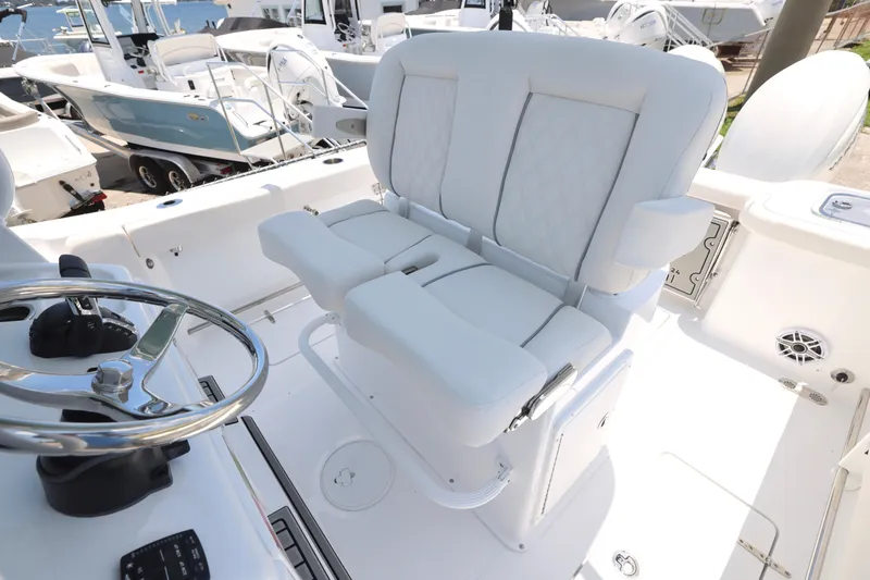 Slide: The Image of 2027 Sea Hunt Gamefish 25 boat interior with white seating and steering wheel. - 8