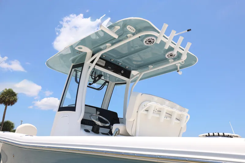 Slide: The Image of 2027 Sea Hunt Gamefish 25 boat with T-top and rod holders under a clear blue sky. - 15