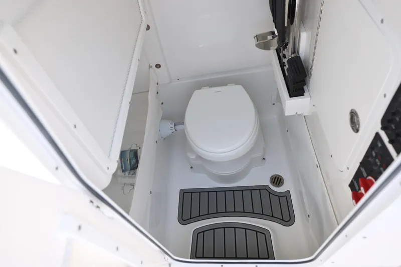Slide: The Image of 2027 Sea Hunt Gamefish 25 boat interior with compact marine toilet and storage. - 26